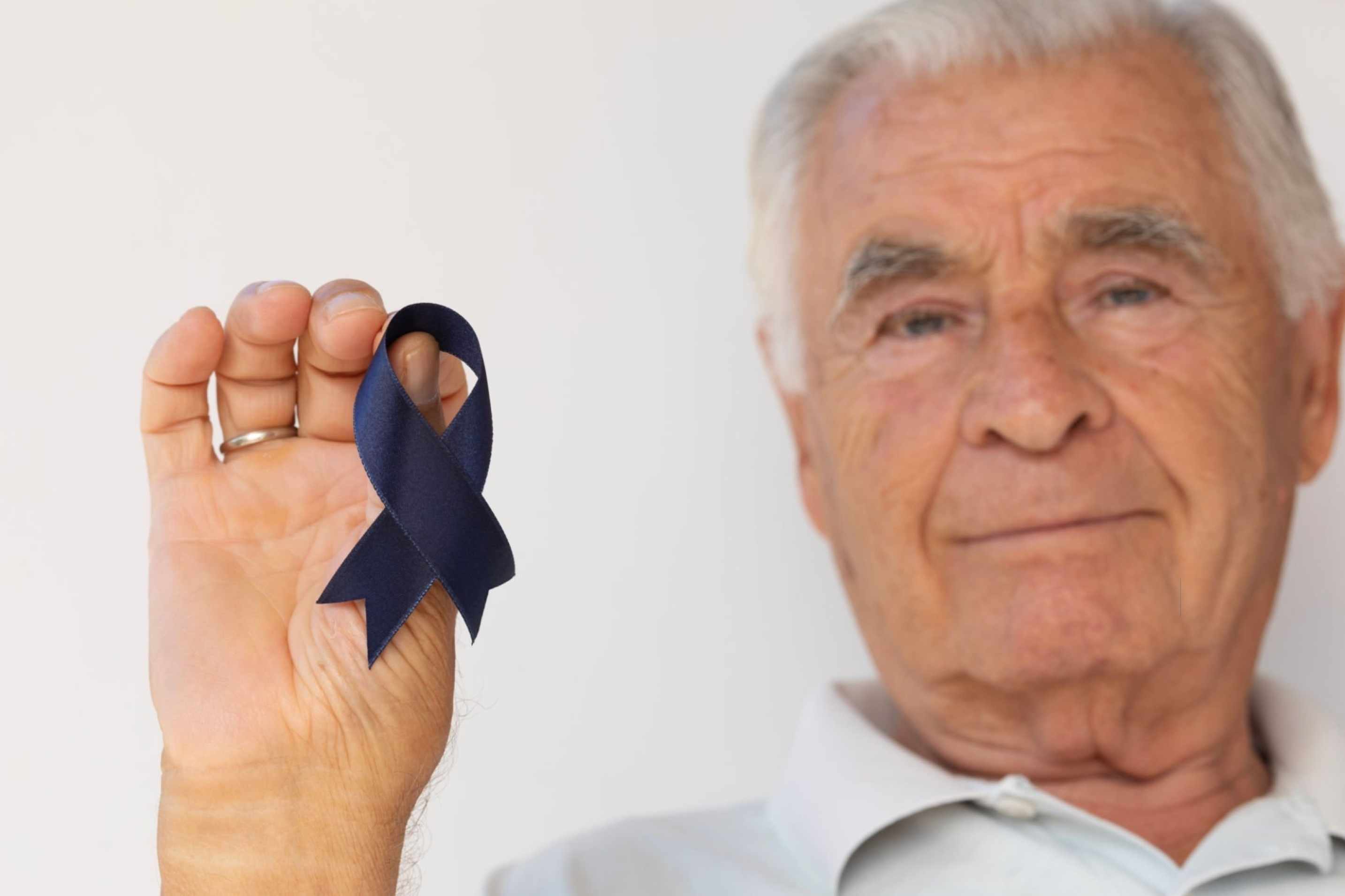 Hombre muestra cinta azul contra el cancer de prostata